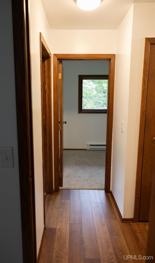 corridor featuring dark hardwood / wood-style flooring and baseboard heating