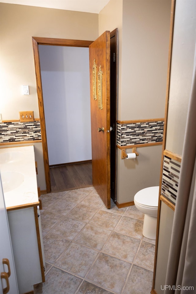 bathroom with vanity, toilet, backsplash, and wood-type flooring