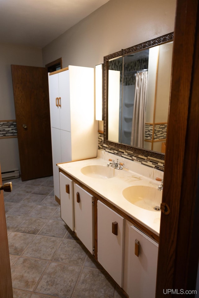 bathroom with a baseboard heating unit, tile patterned flooring, and vanity