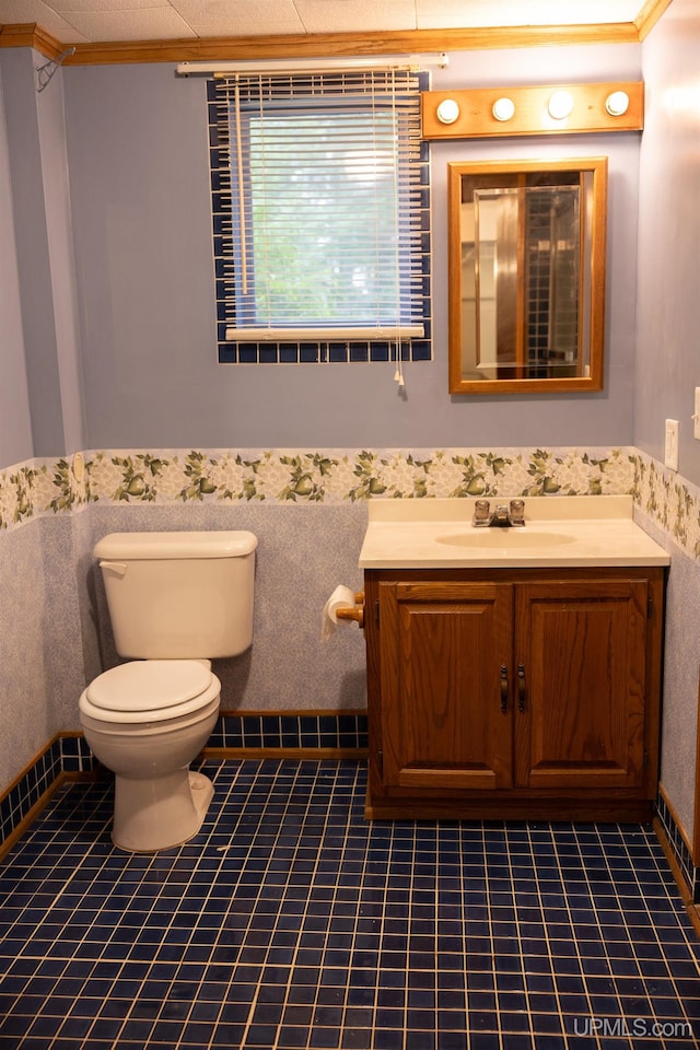 bathroom with tile patterned floors, toilet, crown molding, and vanity