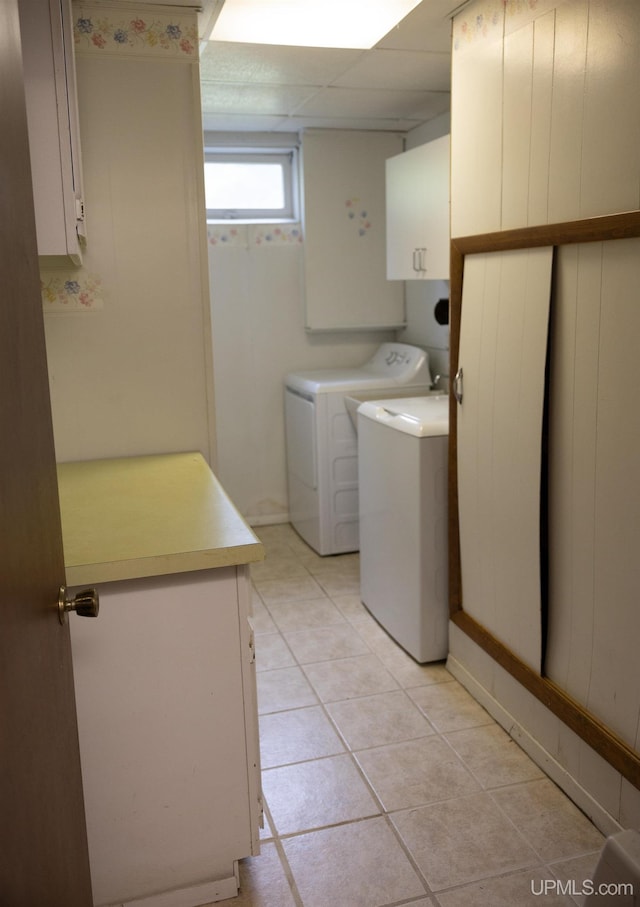 washroom with cabinets, washer and dryer, and light tile patterned flooring