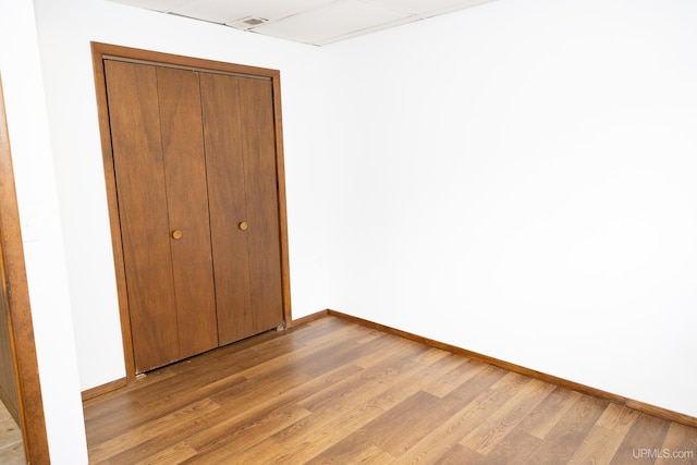 unfurnished bedroom featuring light hardwood / wood-style flooring and a closet