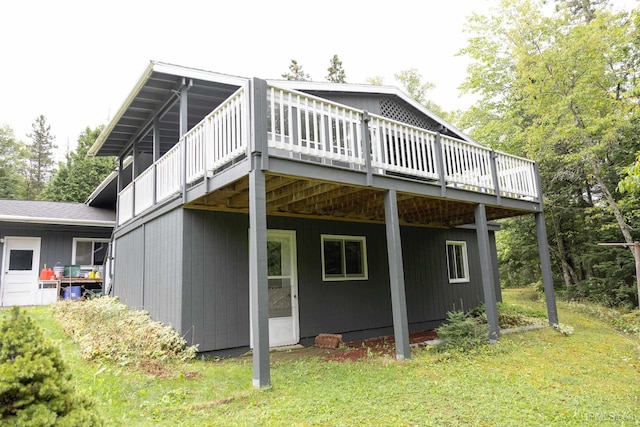 rear view of house featuring a lawn and a deck