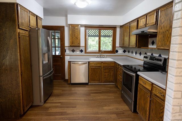 kitchen featuring backsplash, stainless steel appliances, dark hardwood / wood-style floors, and sink