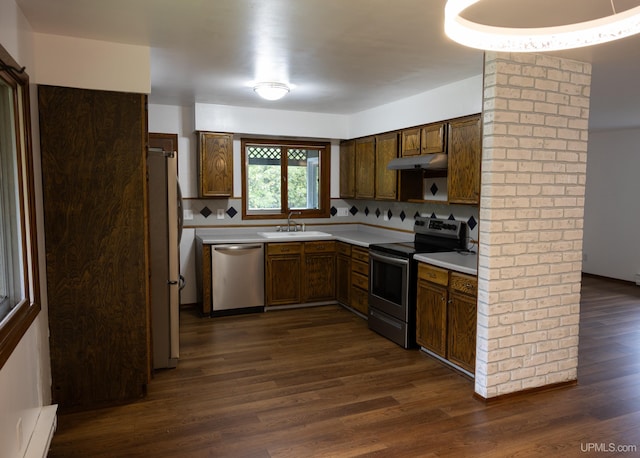 kitchen featuring dark hardwood / wood-style flooring, tasteful backsplash, stainless steel appliances, sink, and baseboard heating