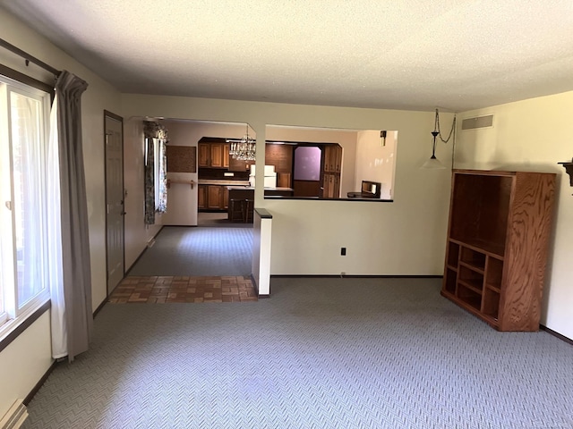 unfurnished living room with a textured ceiling, a baseboard radiator, and dark colored carpet