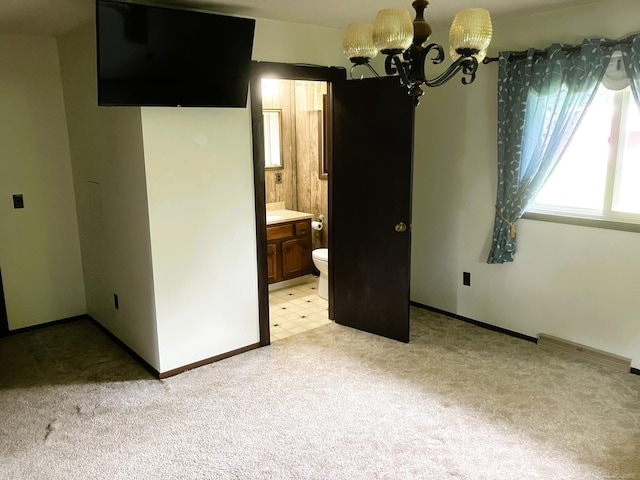 empty room with a notable chandelier and light colored carpet