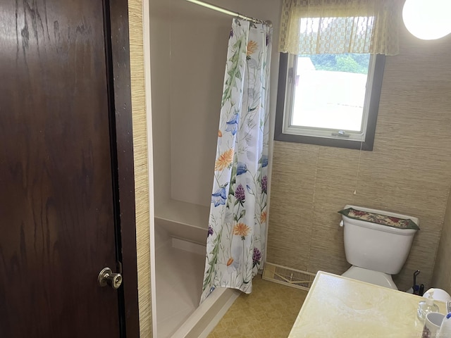 bathroom featuring toilet and a shower with shower curtain