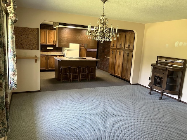 kitchen with dark colored carpet, a center island, white fridge, and decorative light fixtures