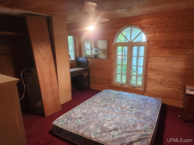 bedroom featuring wood ceiling, dark carpet, ceiling fan, and wooden walls