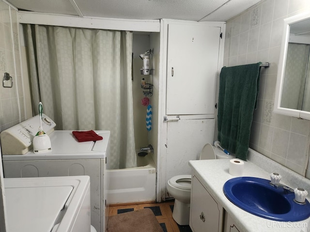 full bathroom featuring shower / bath combo, toilet, tile walls, washer and clothes dryer, and vanity