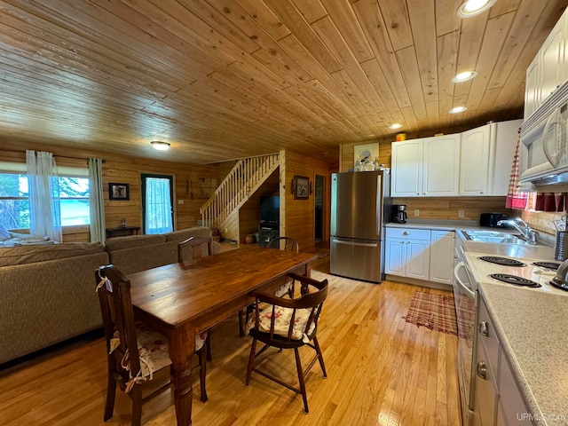 dining room featuring a wealth of natural light, light wood-type flooring, and wooden ceiling