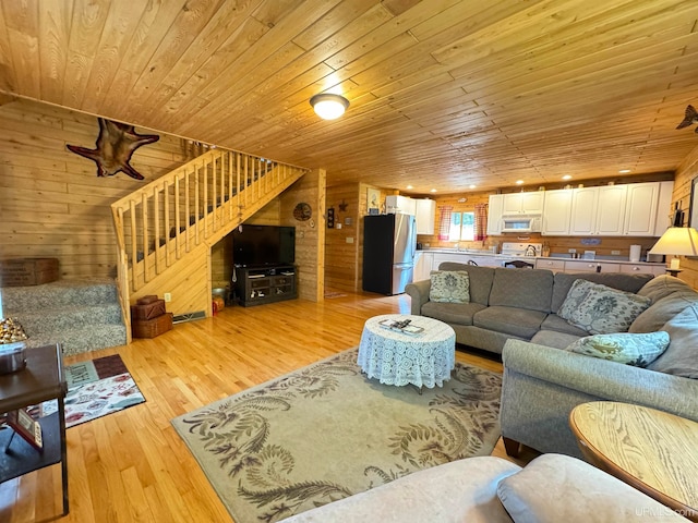 living room with light wood-type flooring, wood walls, and wooden ceiling