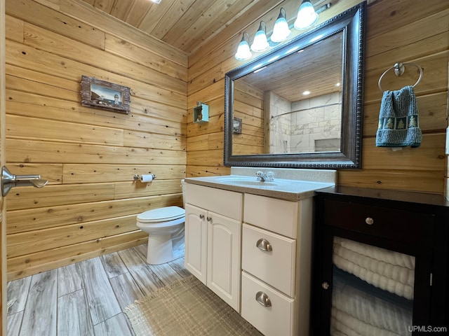 bathroom with wooden walls, wooden ceiling, hardwood / wood-style floors, toilet, and vanity