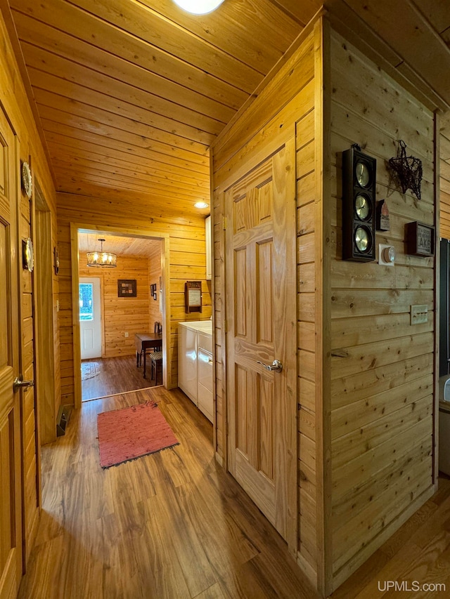 hall with hardwood / wood-style floors, wood ceiling, and wood walls