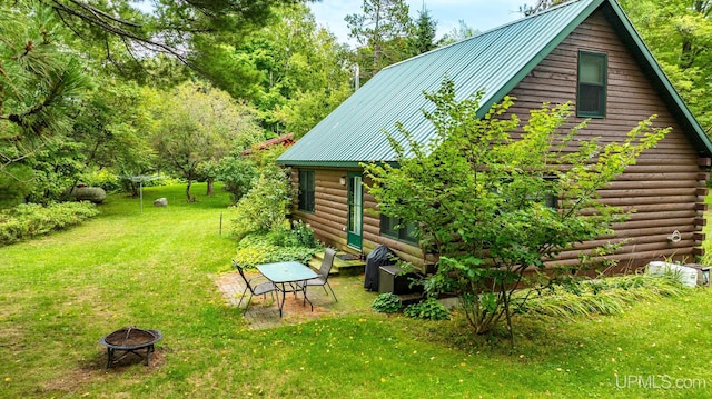 exterior space with a yard and an outdoor fire pit