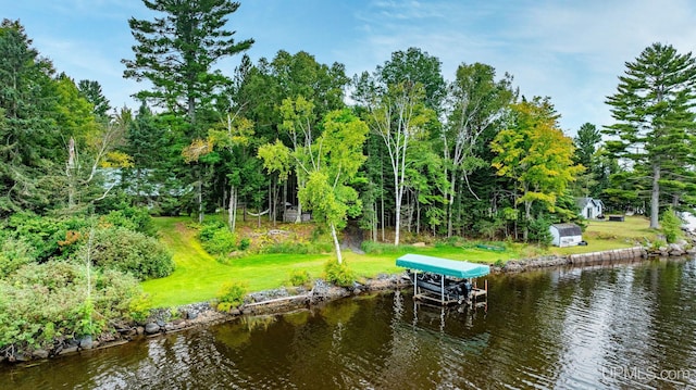 view of dock with a water view and a lawn