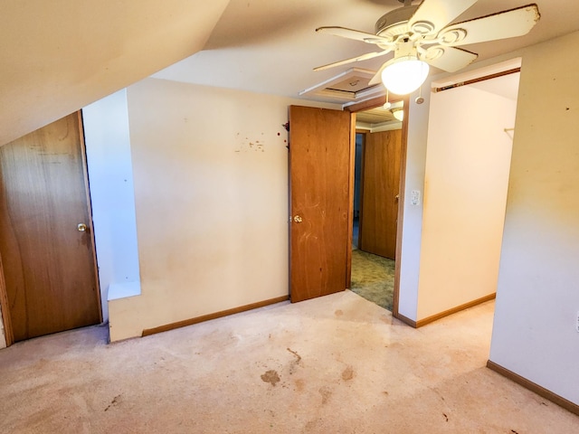 carpeted empty room featuring ceiling fan and vaulted ceiling