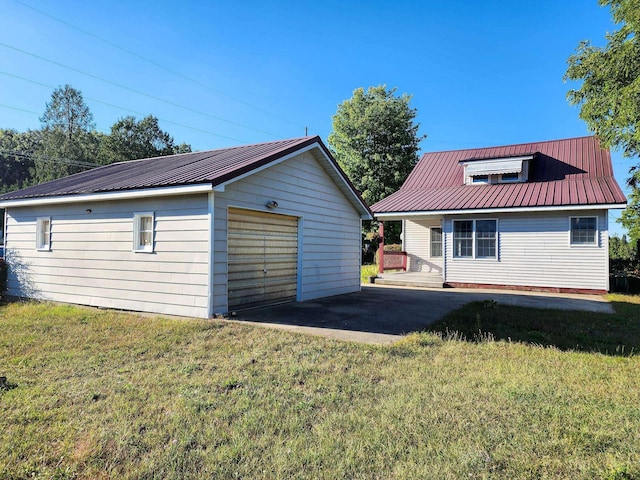 295 W Birch St, Harrison, MI 48625 - rear view of house with a detached garage, an outdoor structure, a metal roof, and a lawn