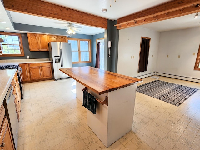 kitchen featuring plenty of natural light, ceiling fan, stainless steel appliances, and wood counters