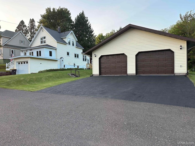 view of front of house featuring a garage, an outbuilding, and a front yard