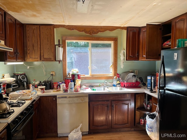 kitchen featuring light wood-type flooring, exhaust hood, white appliances, and sink