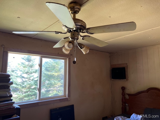 unfurnished bedroom with ceiling fan and wood walls