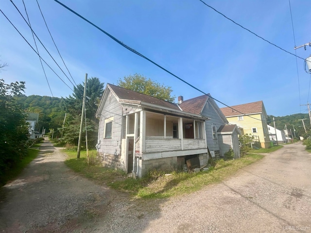 view of side of home featuring covered porch