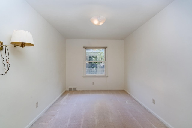 spare room featuring light colored carpet