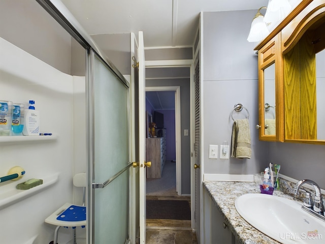 bathroom with a shower with door and vanity