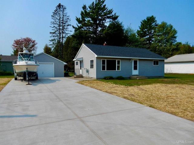 single story home with an outdoor structure, a garage, and a front lawn