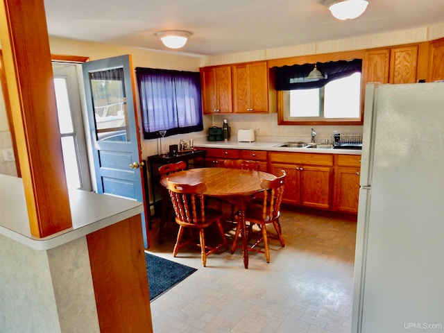 kitchen with white refrigerator, sink, and a healthy amount of sunlight