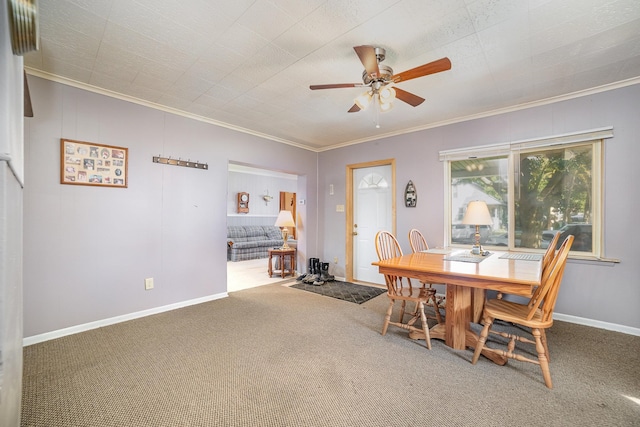 carpeted dining space featuring ornamental molding and ceiling fan