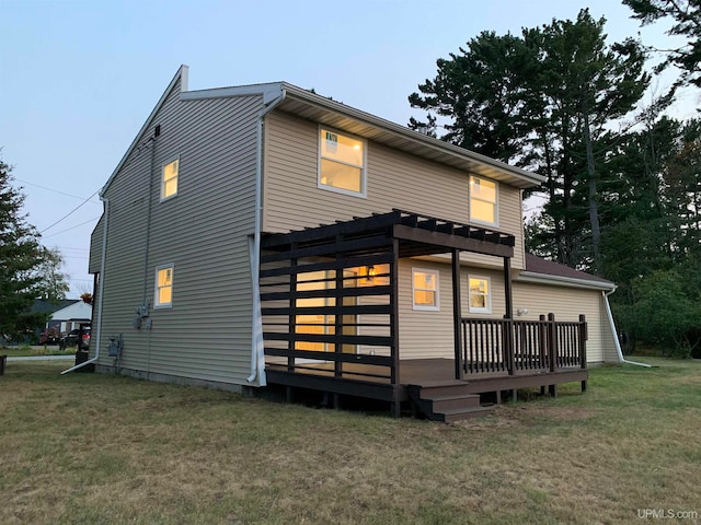 back of property featuring a lawn and a wooden deck