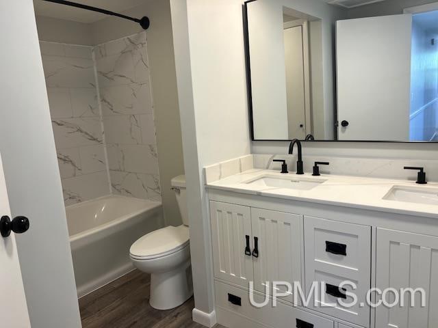 full bathroom featuring vanity, toilet, wood-type flooring, and tiled shower / bath