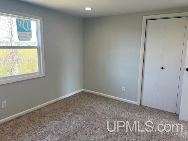 unfurnished bedroom with carpet and a closet