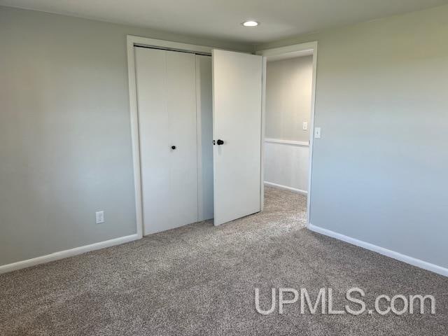 unfurnished bedroom with carpet and a closet