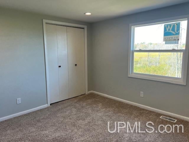 unfurnished bedroom featuring carpet floors and a closet