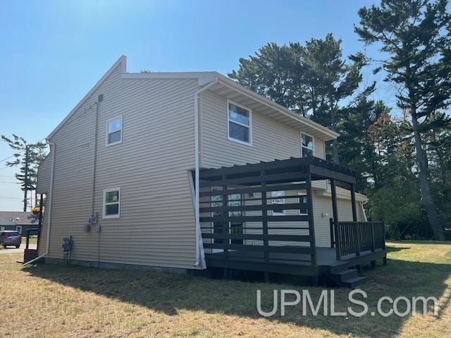 view of property exterior featuring a deck and a lawn