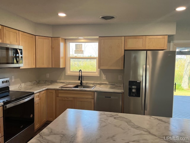 kitchen featuring light brown cabinets, stainless steel appliances, and sink