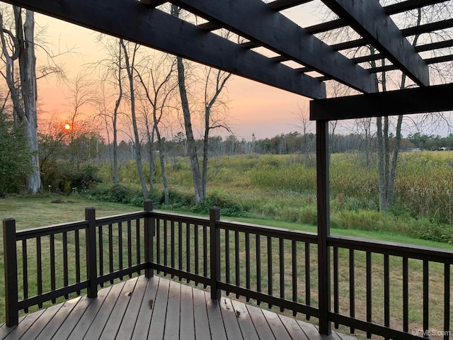 deck at dusk with a lawn and a pergola