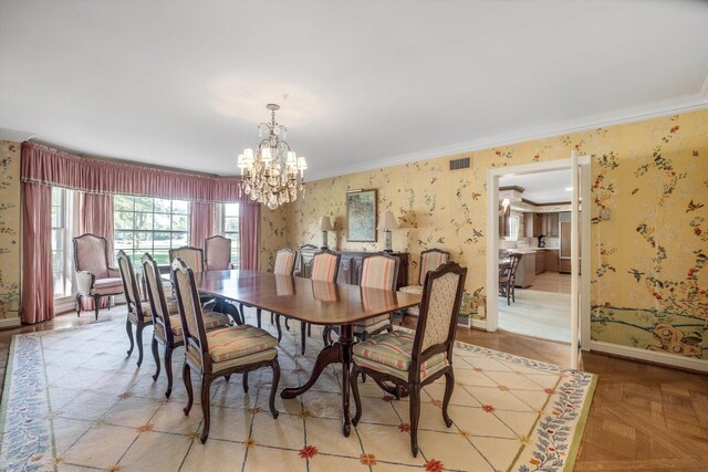 dining room with light parquet floors, crown molding, and an inviting chandelier