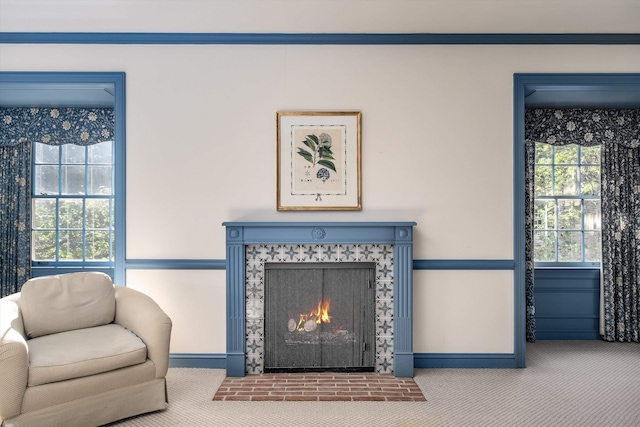 interior space with ornamental molding and a tiled fireplace