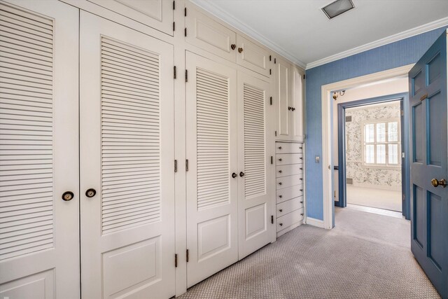 hallway featuring crown molding and light colored carpet