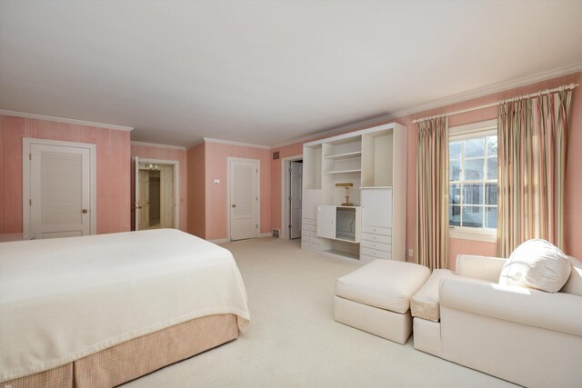 bedroom with crown molding, ensuite bathroom, and carpet flooring