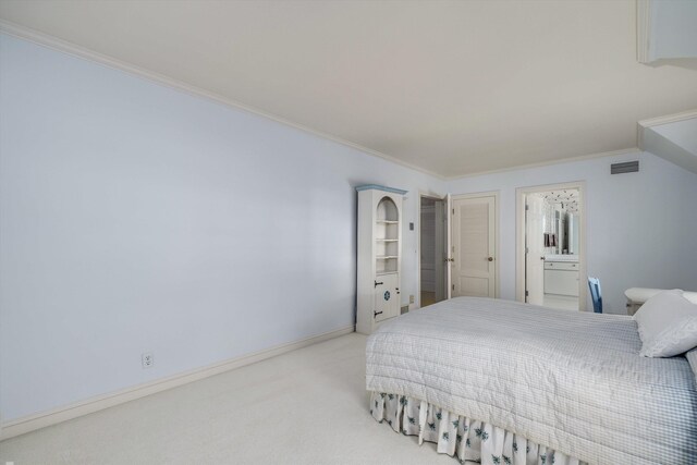 bedroom with crown molding, light colored carpet, and connected bathroom