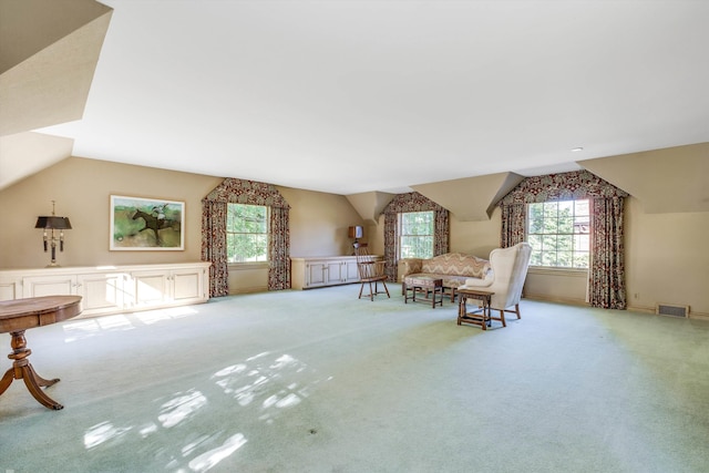 living area with lofted ceiling and light colored carpet