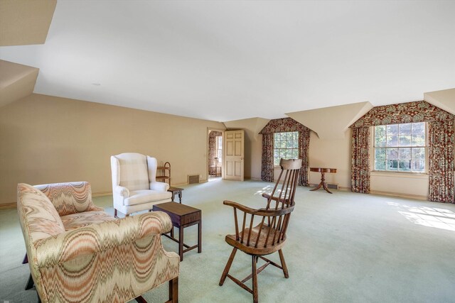 living area with lofted ceiling and light carpet