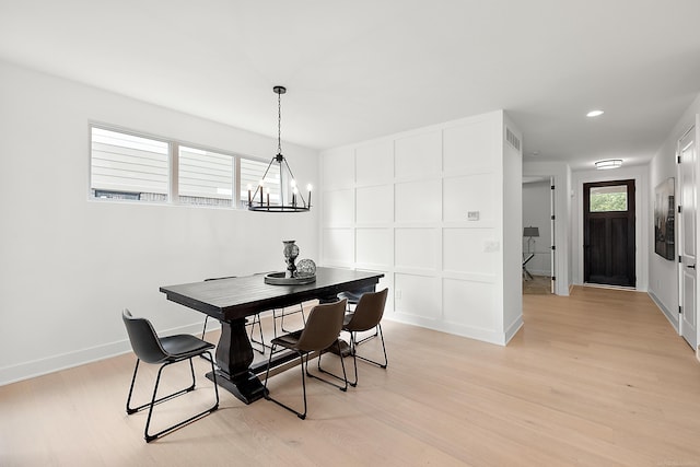 dining space featuring a wealth of natural light, an inviting chandelier, and light hardwood / wood-style floors