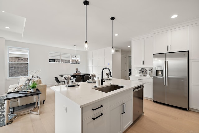 kitchen featuring light hardwood / wood-style floors, white cabinets, sink, a kitchen island with sink, and appliances with stainless steel finishes